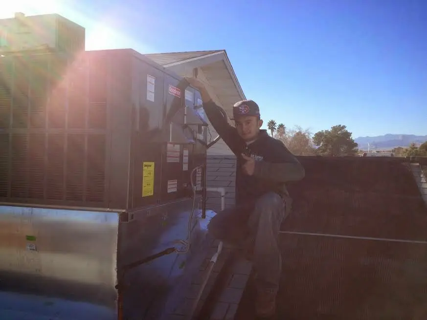 HVAC technician performing Boiler Repair on a rooftop unit in Temple